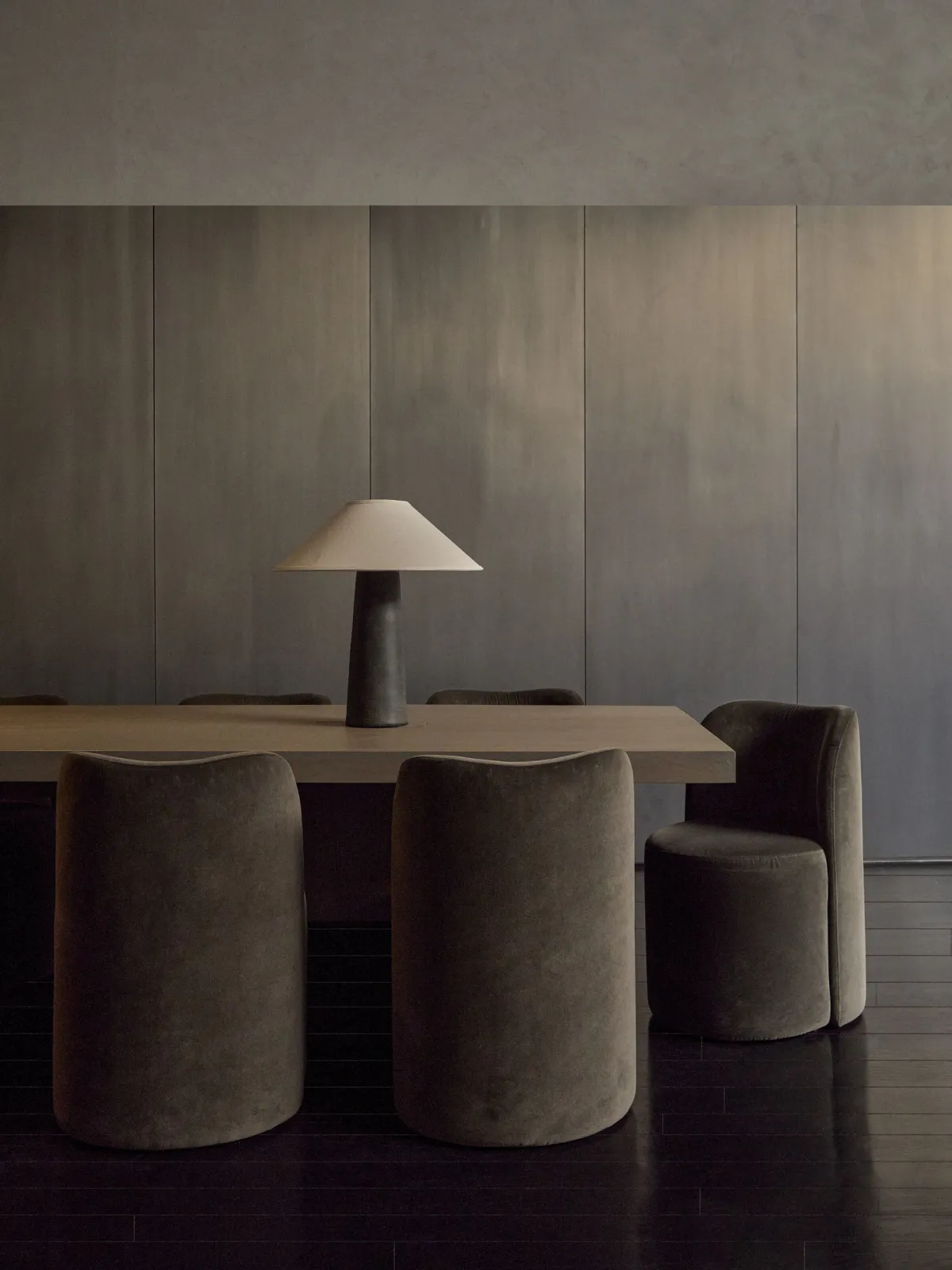 BILT HQ — patina metal wall panels, walnut table, and custom brown velvet chairs